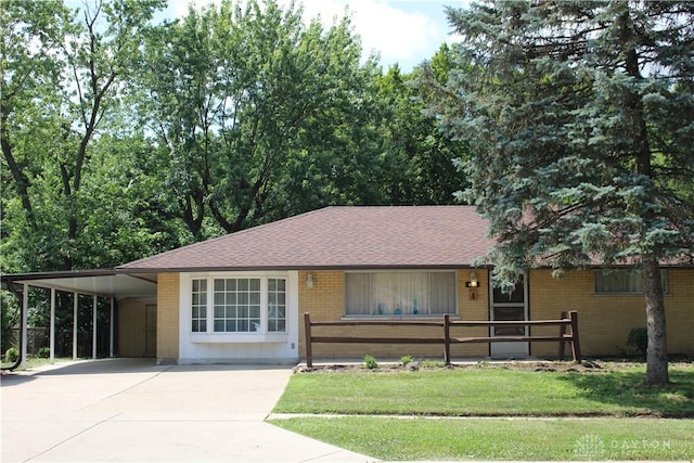 4912 Powell Rd, Huber Heights, OH 45424 - ranch-style house with a carport, driveway, brick siding, roof with shingles, and a front yard