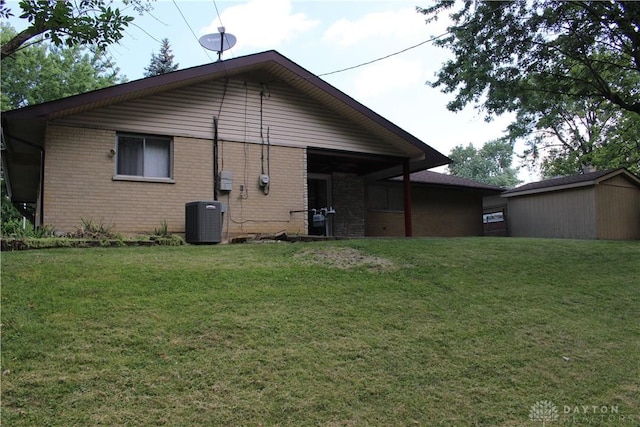 4912 Powell Rd, Huber Heights, OH 45424 - back of property featuring a yard, brick siding, and a storage shed