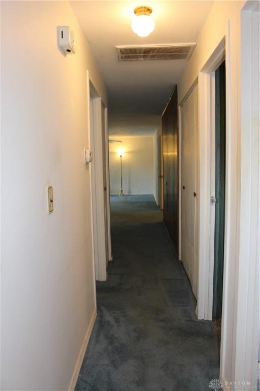 4912 Powell Rd, Huber Heights, OH 45424 - corridor with dark colored carpet and baseboards