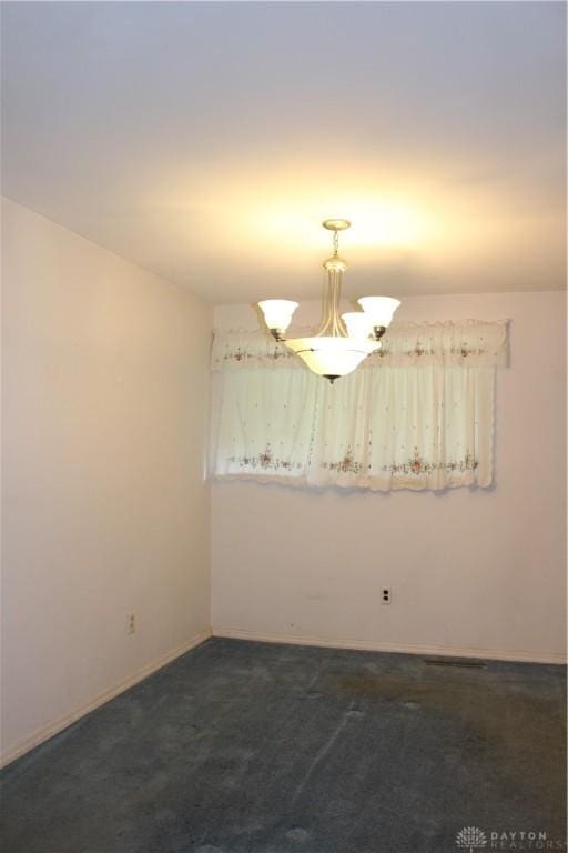 4912 Powell Rd, Huber Heights, OH 45424 - unfurnished room with dark carpet and a chandelier
