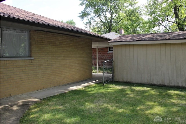 4912 Powell Rd, Huber Heights, OH 45424 - view of side of property with brick siding, a yard, and roof with shingles