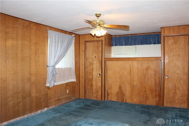 4912 Powell Rd, Huber Heights, OH 45424 - unfurnished bedroom featuring carpet floors, wood walls, and a ceiling fan