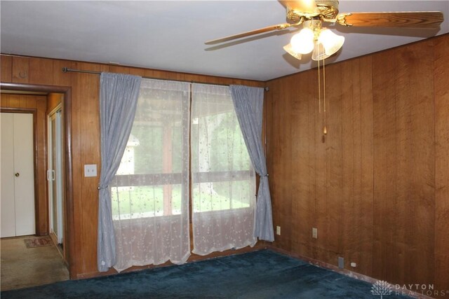 4912 Powell Rd, Huber Heights, OH 45424 - empty room with carpet, wood walls, and a ceiling fan