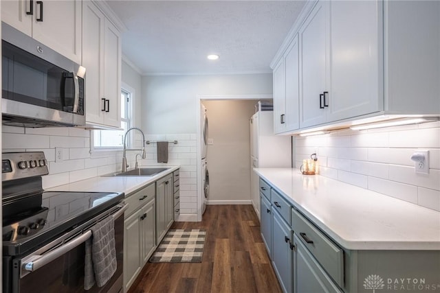 1097 Trudy Ct, Clearcreek Twp, OH 45036 - kitchen with stainless steel appliances, dark wood finished floors, light countertops, backsplash, and crown molding