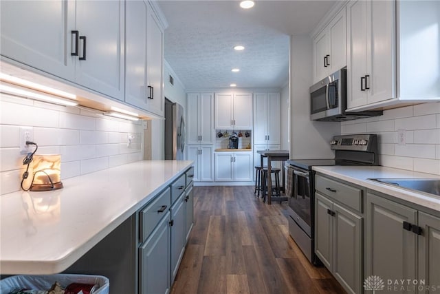 1097 Trudy Ct, Clearcreek Twp, OH 45036 - kitchen with stainless steel appliances, backsplash, recessed lighting, white cabinetry, and a textured ceiling