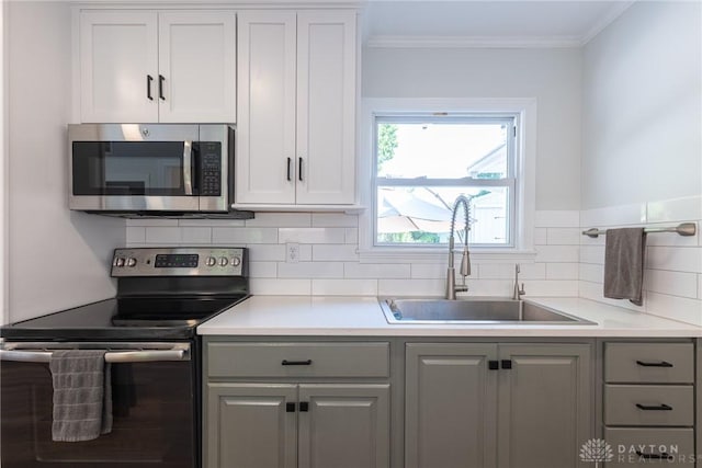 1097 Trudy Ct, Clearcreek Twp, OH 45036 - kitchen featuring appliances with stainless steel finishes, gray cabinets, tasteful backsplash, light countertops, and crown molding