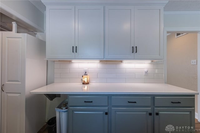 1097 Trudy Ct, Clearcreek Twp, OH 45036 - kitchen with decorative backsplash, light countertops, crown molding, white cabinetry, and blue cabinets