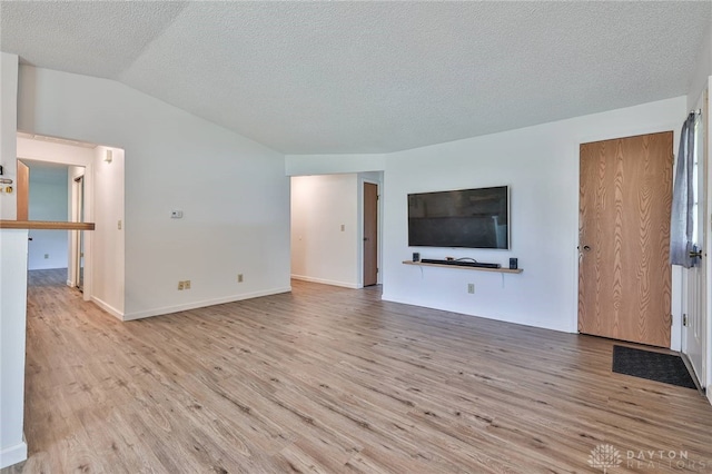 5979 Timbergate Trl, Dayton, OH 45424 - unfurnished living room with wood finished floors, vaulted ceiling, and a textured ceiling