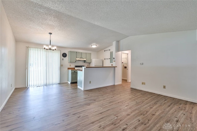 5979 Timbergate Trl, Dayton, OH 45424 - unfurnished living room featuring a chandelier, light wood-style flooring, vaulted ceiling, and a textured ceiling