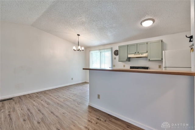 5979 Timbergate Trl, Dayton, OH 45424 - kitchen with a textured ceiling, green cabinets, a chandelier, freestanding refrigerator, and wood finished floors