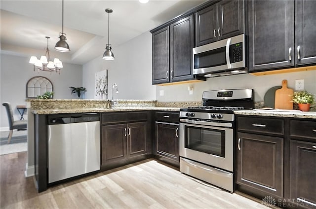 1310 Bourdeaux Way, Clearcreek Twp, OH 45458 - kitchen with appliances with stainless steel finishes, light wood-type flooring, a peninsula, a chandelier, and light stone countertops
