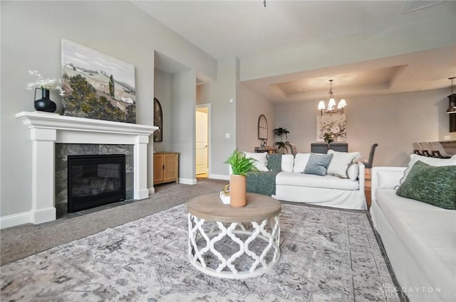 1310 Bourdeaux Way, Clearcreek Twp, OH 45458 - living room featuring a tray ceiling, a chandelier, a premium fireplace, and carpet flooring