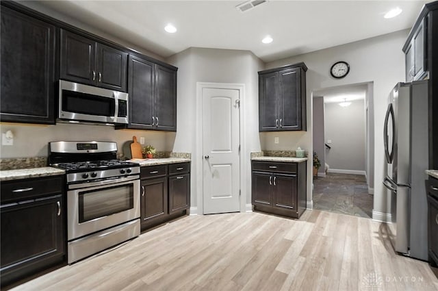 1310 Bourdeaux Way, Clearcreek Twp, OH 45458 - kitchen with appliances with stainless steel finishes, light wood-type flooring, light stone counters, recessed lighting, and dark cabinetry