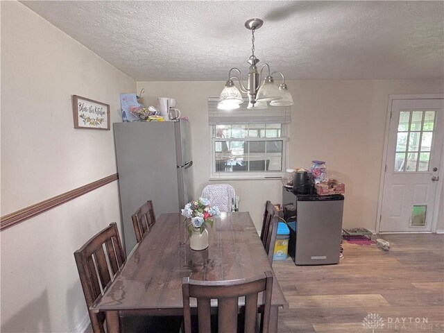 11629 Pippin Rd, Colerain Twp, OH 45231 - dining space with a chandelier, wood finished floors, and a textured ceiling