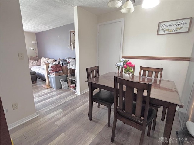 11629 Pippin Rd, Colerain Twp, OH 45231 - dining space with wood finished floors, a textured ceiling, and a chandelier