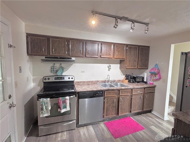11629 Pippin Rd, Colerain Twp, OH 45231 - kitchen with stainless steel appliances, light wood-style floors, exhaust hood, light countertops, and dark brown cabinets