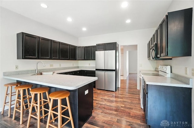5567 Day Rd, Colerain Twp, OH 45252 - kitchen with a peninsula, white electric range, freestanding refrigerator, wood finished floors, and light countertops