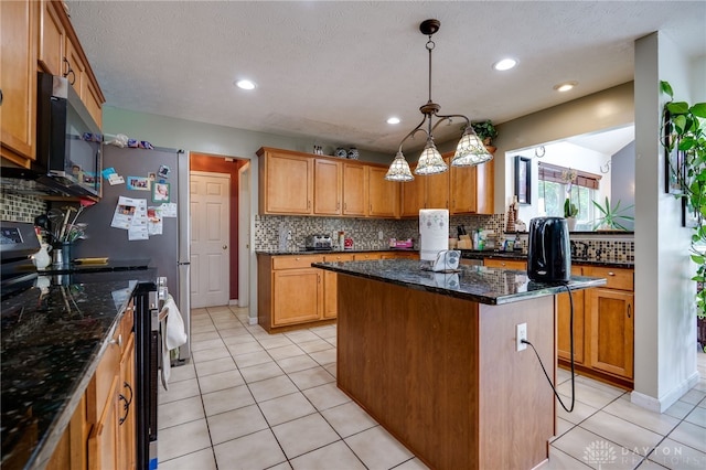 213 Bentridge Dr, Clearcreek Twp, OH 45458 - kitchen with electric stove, tasteful backsplash, a center island, stainless steel microwave, and light tile patterned floors