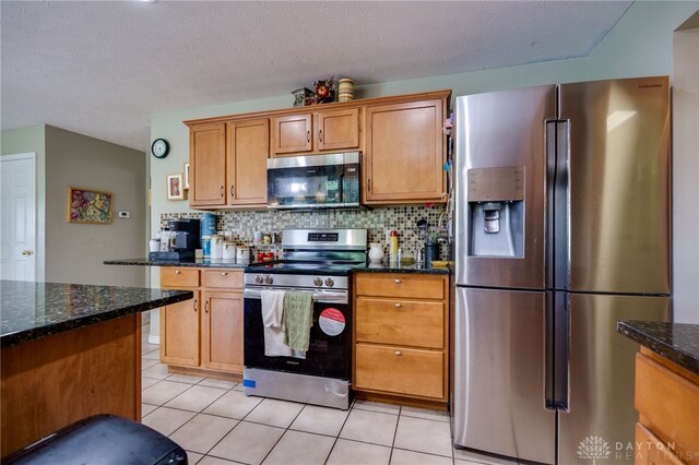 213 Bentridge Dr, Clearcreek Twp, OH 45458 - kitchen with appliances with stainless steel finishes, light tile patterned floors, decorative backsplash, dark stone countertops, and a textured ceiling