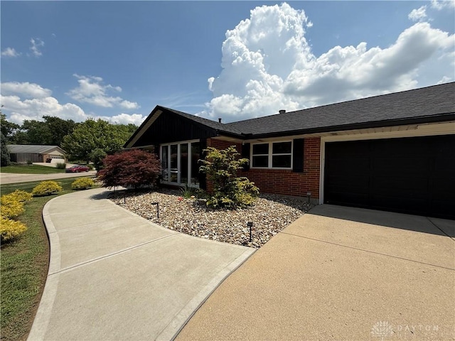 4220 Sillman Pl, Kettering, OH 45440 - view of front of house featuring brick siding, driveway, a shingled roof, and an attached garage