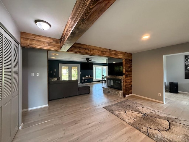 4220 Sillman Pl, Kettering, OH 45440 - unfurnished living room featuring light wood-style flooring, a ceiling fan, a stone fireplace, and beamed ceiling