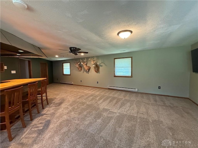 4220 Sillman Pl, Kettering, OH 45440 - basement featuring a textured ceiling, carpet, a ceiling fan, a dry bar, and a baseboard radiator