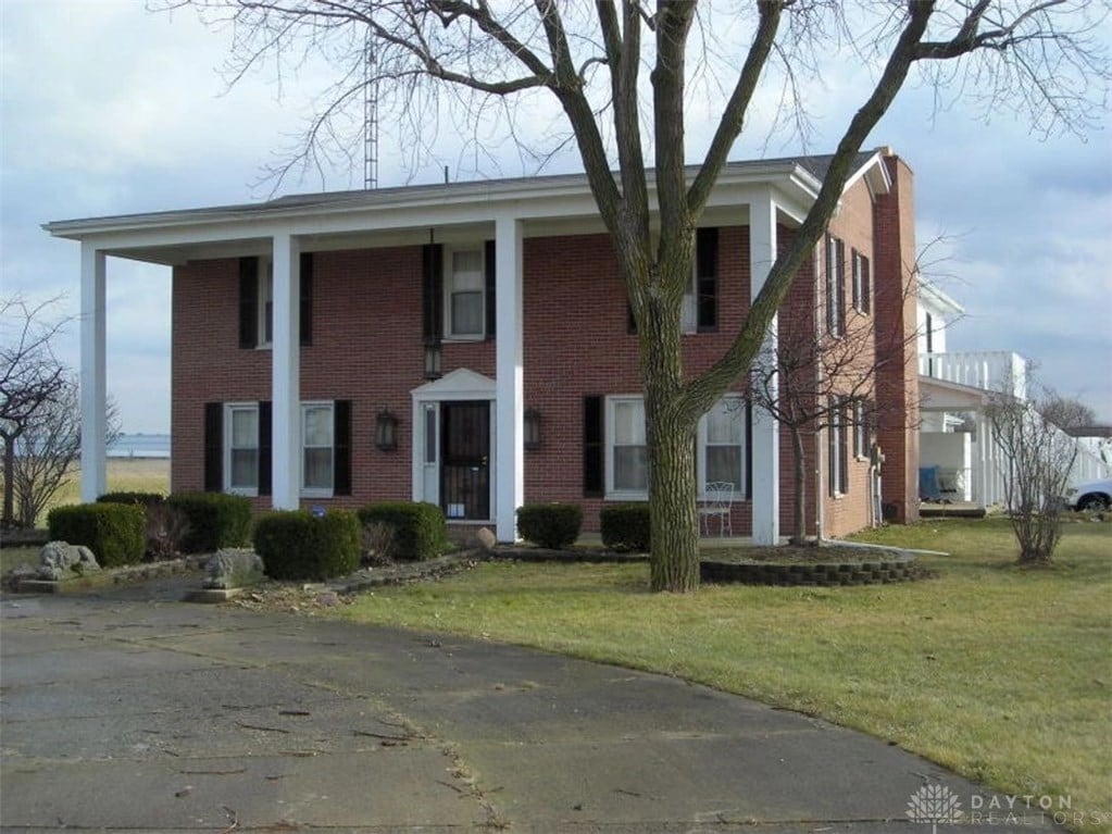 neoclassical / greek revival house featuring a front lawn