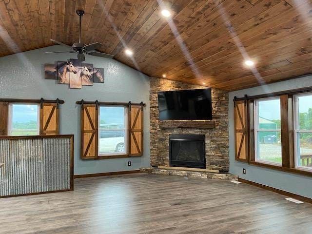 unfurnished living room featuring ceiling fan, hardwood / wood-style floors, and wooden ceiling