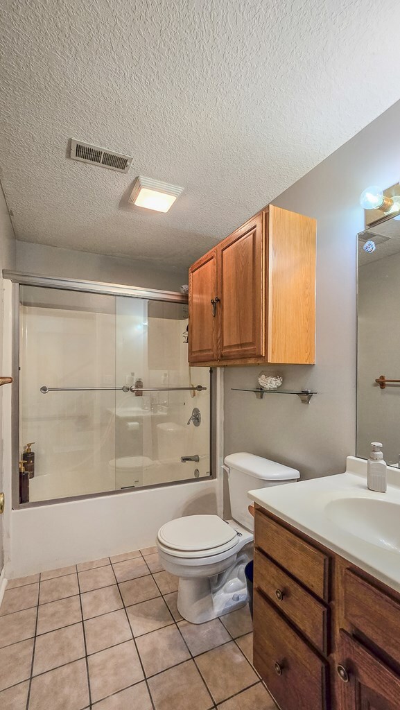 26484 State Highway 3, Kirksville, MO 63501 - bathroom featuring vanity, a textured ceiling, tile patterned floors, and shower / bath combination with glass door