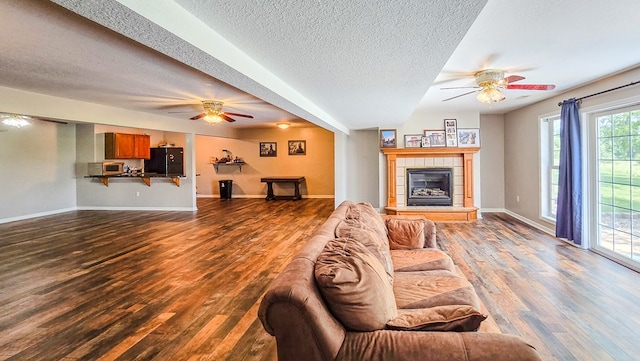 26484 State Highway 3, Kirksville, MO 63501 - living room with ceiling fan, wood finished floors, a textured ceiling, and a tiled fireplace