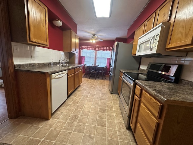 kitchen featuring white appliances, tasteful backsplash, ceiling fan, and sink