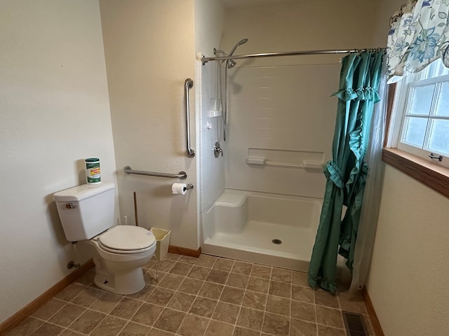 bathroom with a shower with shower curtain and toilet