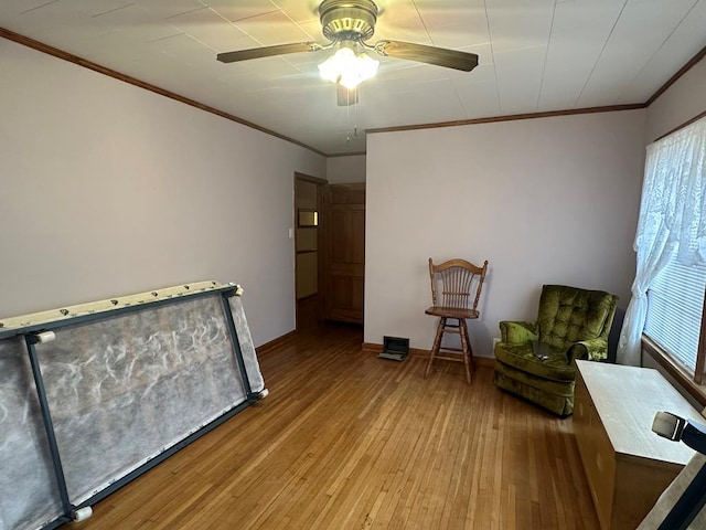 sitting room with ceiling fan, light hardwood / wood-style floors, and ornamental molding