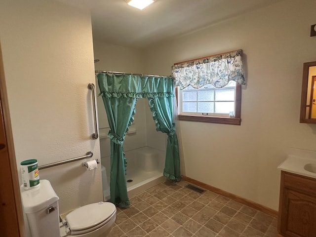 bathroom featuring vanity, toilet, and walk in shower