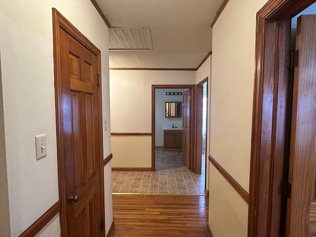 hall featuring sink, light hardwood / wood-style floors, and ornamental molding