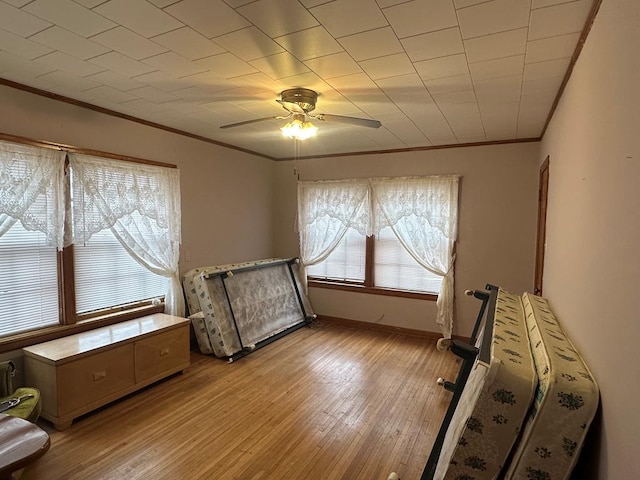 bedroom featuring ceiling fan, light hardwood / wood-style floors, and crown molding