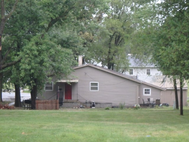 rear view of property with a yard