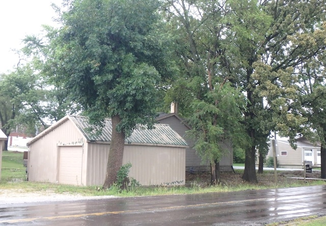 view of property exterior with a garage and an outdoor structure