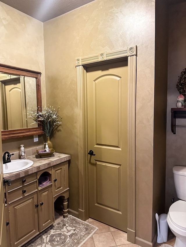 bathroom with vanity, tile patterned flooring, and toilet