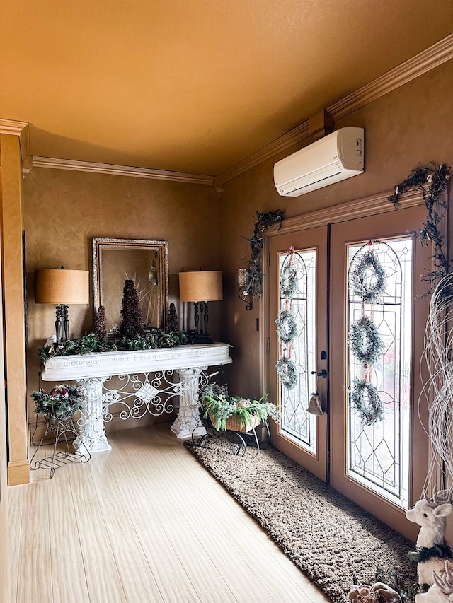 foyer entrance with a wall unit AC, wood finished floors, and crown molding