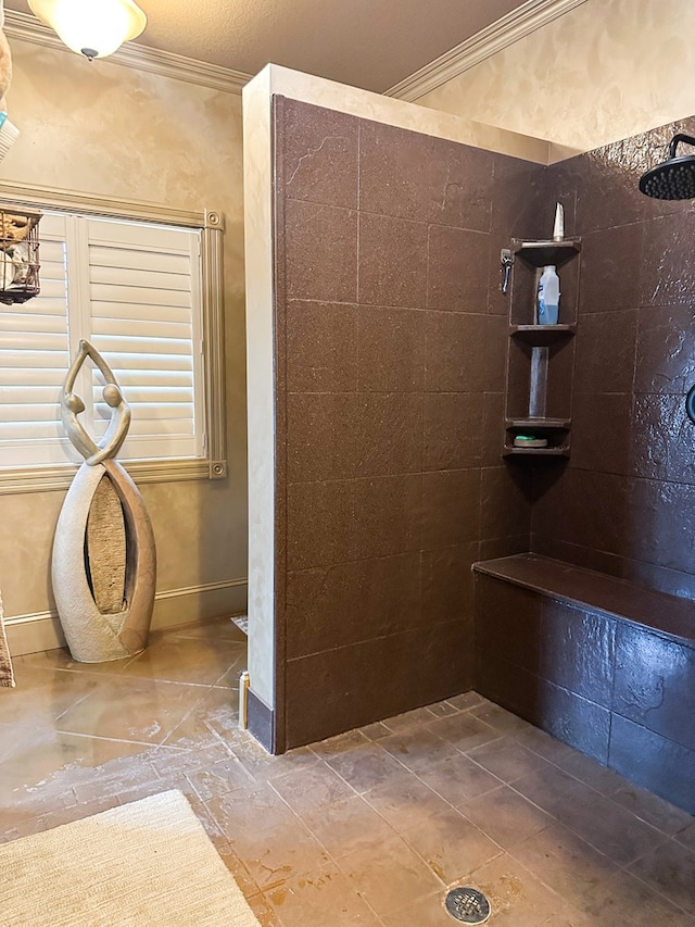 full bathroom with crown molding, a tile shower, and baseboards