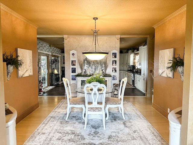 dining room with crown molding, baseboards, and wood finished floors