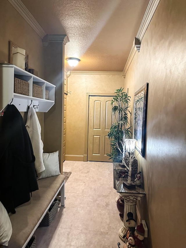 mudroom with crown molding and a textured ceiling