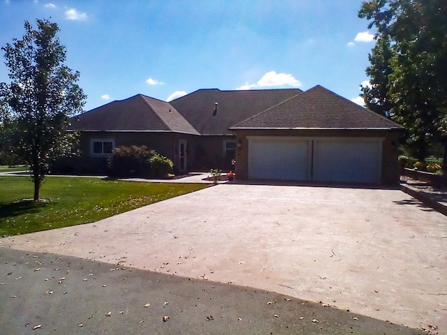 ranch-style house with an attached garage, a front lawn, and concrete driveway