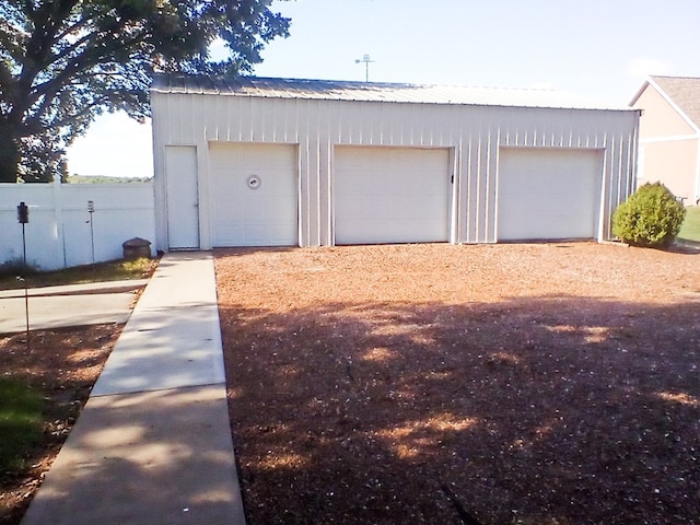 detached garage featuring fence