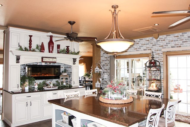 kitchen with a ceiling fan, a healthy amount of sunlight, visible vents, and white cabinets