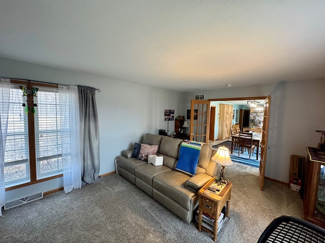 living area with baseboards, visible vents, and carpet floors