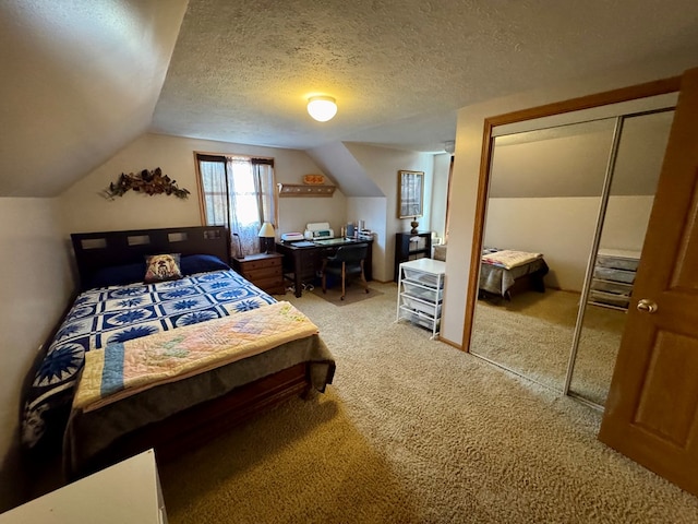 bedroom featuring light carpet, a textured ceiling, multiple closets, and vaulted ceiling