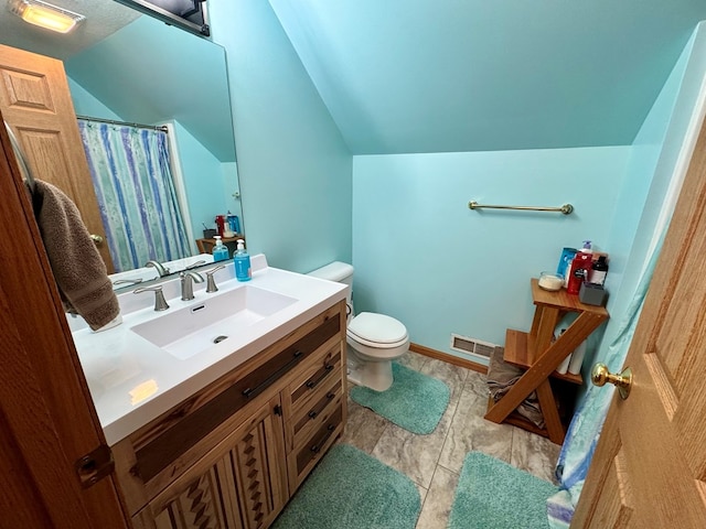 bathroom featuring vanity, lofted ceiling, toilet, and visible vents