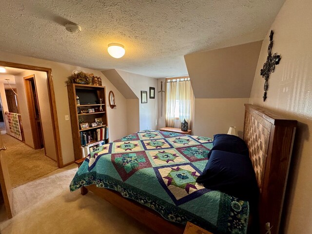 bedroom with light colored carpet and a textured ceiling